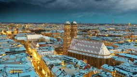 Munich aerial skyline view at night with snow winter time christmas, fly over marienplatz sqaure frauenkirche church and town hall, munich night drone video birds view. Munich Frauenkirche,Cathedral.