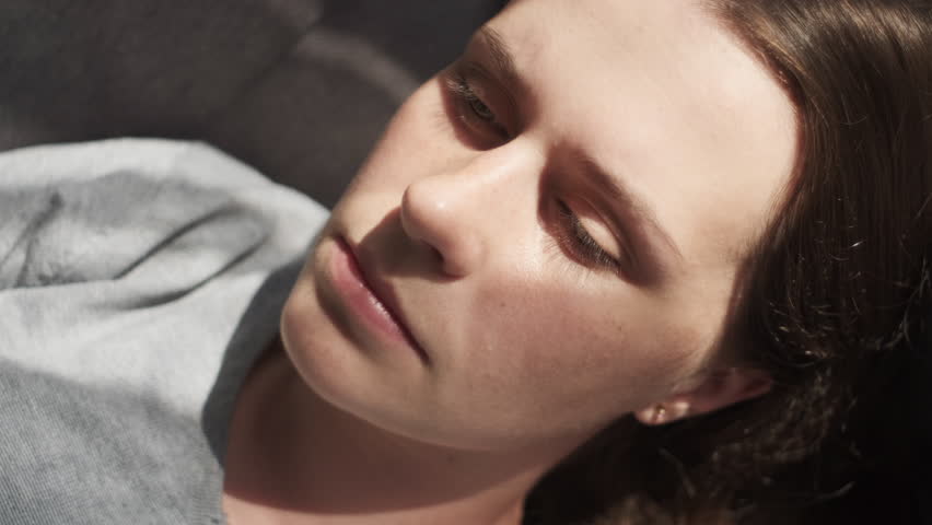 Close-up of sad young caucasian woman lying on couch suffers from heartache cover face with hands feels desperate unhappy unwell having mental pain or serious health problems. Divorce abortion concept | Shutterstock HD Video #1107896989
