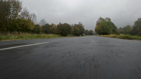 Low Perspective Camera car of country road in wet and slippery conditions - Autumn