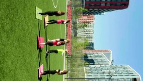 Group of woman do yoga warrior pose. Group of five sporty women practicing yoga lesson with instructor.  Aerial vertical, vertical video background.