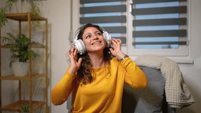 Woman wearing headset relaxing at home with music, enjoying leisure time.