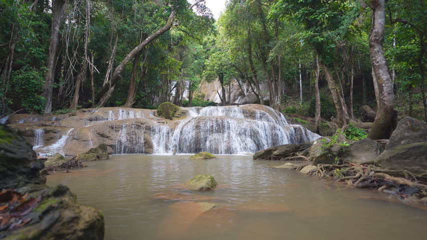 landscape waterfall clear flow motion water with rocks and natural roots to fresh relax with nature trees jungle or green forest in summer at Pha Tad Waterfall FL3 in KhuanSrinagarindra National Park Royalty-Free Stock Footage #1107907957