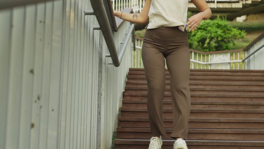 Caucasian young woman dancing urban dance on the stairs in the city. Rhythmic musical dances of girls. High quality 4k footage