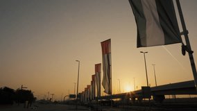 Low angle view of United Arab Emirates national flags on flagpoles in a row waving near the road with beautiful sun light - Powered by Shutterstock - Get 15% off with code: PIKWIZARD15