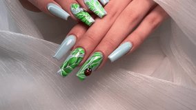 video of nails with green Leafs design on nails. Beautiful girl nails manicure with nail art designs
