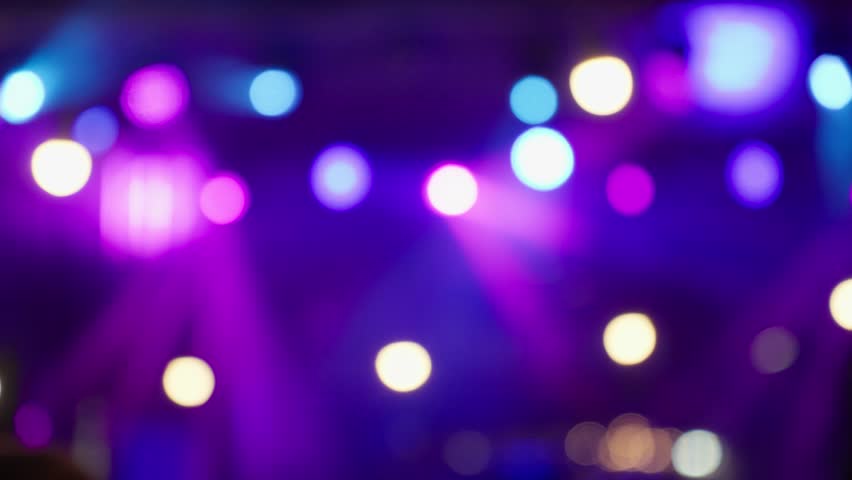Happy people watching amazing musical concert. Bright colorful stage lighting. Selective focus, blurred. Nightlife and entertainment concept. People with raised arms on music event with lights Royalty-Free Stock Footage #1107916829