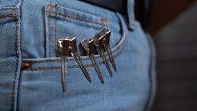 Jeans pocket with metal hair clips attached. Hairdresser hooked up for storage clips to her pants for the convenience of cutting, styling Professional barber tool. Clothespins hairpin for fixing curls