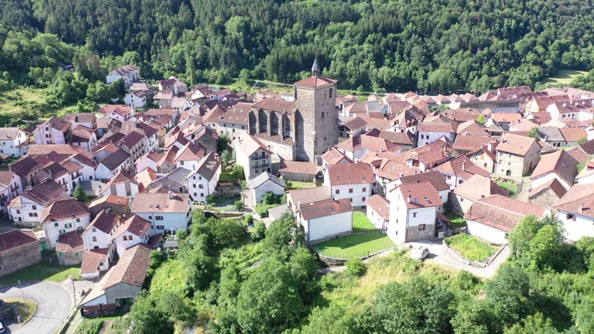Dense urban development of medieval Spanish town of Isaba, view from above. Wide view of settlement and adjacent forests and mountains, view from observation deck, from quadrocopter drone Royalty-Free Stock Footage #1107921577