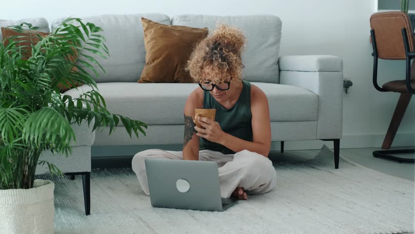 One modern female people sitting on the carpet at home and using laptop to connect internet. Small business and smart working job lifestyle concept with young woman entrepreneur casual. Using notebook
