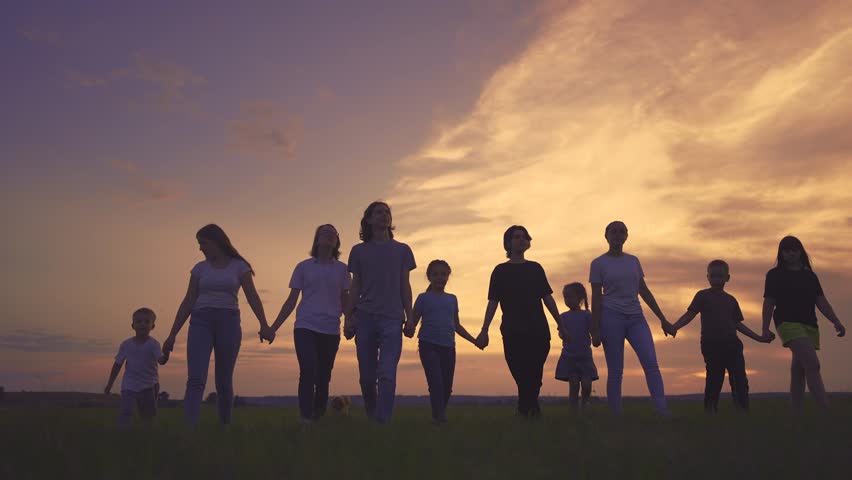 large friendly community family silhouette walk in the park. friendly family holding hands walking in nature in the park. happy family kid concept. silhouette large group people holding hands dream Royalty-Free Stock Footage #1107929237