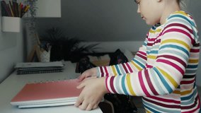Caucasian elementary girl packing schoolbag for school. Shot with RED helium camera in 8K. 