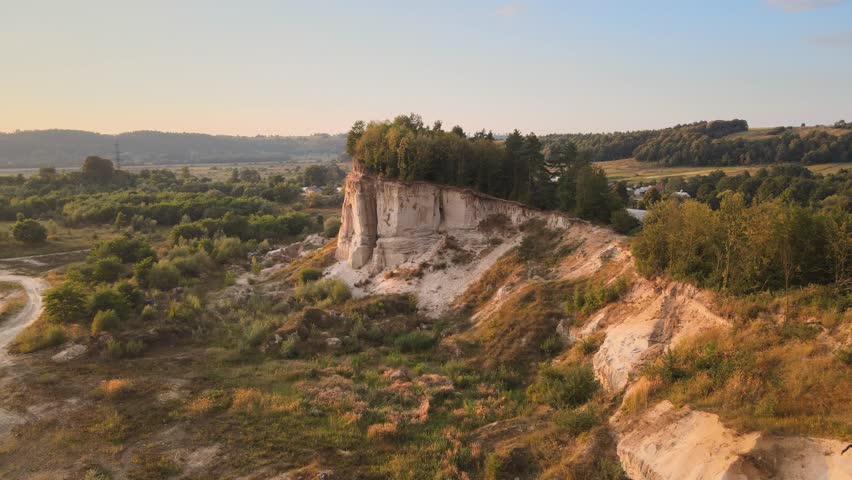 Scenic clay cliff with trees. Clay quarry