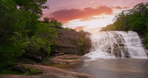 Amazing waterfall in nature Beautiful waterfall video at sunset Sky sunset over waterfall with sunshine orange. Filmed with high quality film cameras. DCI 4K ProRes422