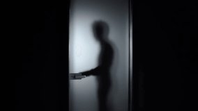 Man open glass door in dark room at minimalist apartment, want go away. Silhouette view - Powered by Shutterstock - Get 15% off with code: PIKWIZARD15