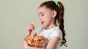 A girl takes chips snacks with lard from a bowl and eats them, portrait on a white background and copy space.