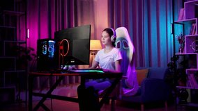 Asian Teen Girl Gamer Smiling To Camera With Crossed Arms While Playing Video Game On Computer
