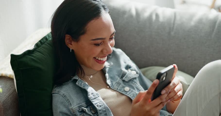 Woman, laugh and typing with phone on sofa, scroll social media or reading funny notification from home. Smartphone user, meme and search website, download digital app and mobile games in living room Royalty-Free Stock Footage #1107947709