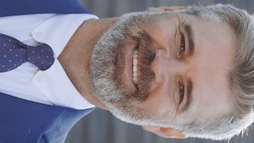 Vertical Video. Smiling Businessman Looking at Camera. Closeup of Happy Male Manager. Portrait of Handsome Mature Office Worker. Cheerful Man Face with Positive Emotion Outdoors - Powered by Shutterstock - Get 15% off with code: PIKWIZARD15