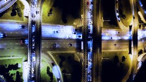 A drone shot over the head of cars driving on a multi-lane at night. Drone shot of a night freeway with multi-level interchanges. Aerial vertical, vertical video background.