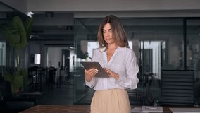 Latin Hispanic 40 years stylish mature professional business woman, smiling European businesswoman CEO holding digital tablet using fintech tab online application standing in modern office, copy space - Powered by Shutterstock - Get 15% off with code: PIKWIZARD15