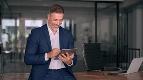 Happy Latin Hispanic bearded stylish mature adult professional business man, smiling Indian senior businessman CEO holding digital tablet using fintech tab application standing inside company office. - Powered by Shutterstock - Get 15% off with code: PIKWIZARD15