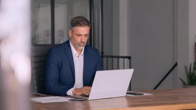 Portrait of mature Indian or Latin business man ceo trader using laptop computer, typing, working in modern office. Middle-age Hispanic smiling handsome businessman entrepreneur looking at laptop. - Powered by Shutterstock - Get 15% off with code: PIKWIZARD15