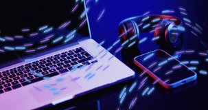 Animation of neon light trails over video game computer equipment. Global video game, digital interface, data processing and connections concept digitally generated video.