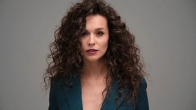 Beautiful brown-haired girl with a perfectly curly flying hair, classic make-up and a blue suit. Beauty face and hair. - Powered by Shutterstock - Get 15% off with code: PIKWIZARD15