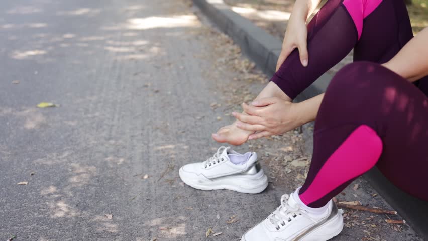 Young adult woman with muscle pain while running. A runner has a sore foot due to plantar fasciitis. Sports injury and medical concept Royalty-Free Stock Footage #1107968553