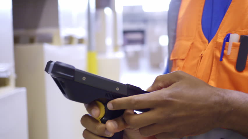 Warehouse employee using barcode scanner device while managing stock inventory closeup. Shipment manager scanning goods with handheld bar code reader in storehouse Royalty-Free Stock Footage #1107969225