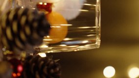 Vertical video. A table with Christmas decorations, Santa's hat, and an empty cup from pinecones. In motion, close-up. - Powered by Shutterstock - Get 15% off with code: PIKWIZARD15