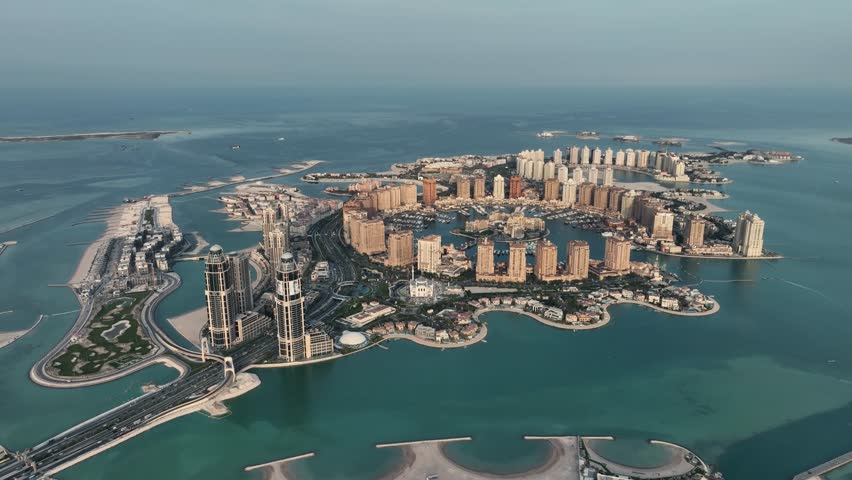 The drone is flying high looking at the Pearl neighbourhood on a sunny day in Doha Qatar Aerial Footage 4K Royalty-Free Stock Footage #1107970427