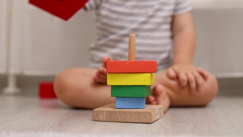 adorable baby boy child playing at home floor with wooden building block set,pyramid puzzle, set of  montessori development toys.happy kid showing with hand the resulat.pyramid upside down.eco safe,4k Royalty-Free Stock Footage #1107972281
