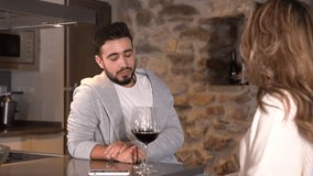 A couple having a glass of wine on a romantic evening in the kitchen of their home, lifestyle of a couple on Valentine's Day. 4k video