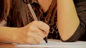 closeup hand of Young woman indoors at home writing notes working at desk writing and solving
