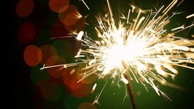 Closeup single sparkler burning Lightening festive sparklers happy bokeh gleaming light background
