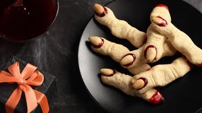 Seamless animation of running spiders on spooky, scary Halloween Witch's fingers from sugar cookies with raspberry jam and almonds. View from above. - Powered by Shutterstock - Get 15% off with code: PIKWIZARD15