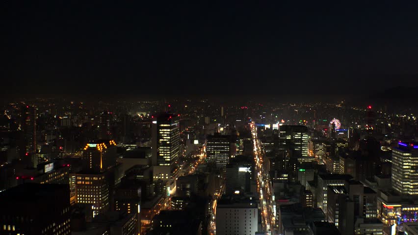 SAPPORO, HOKKAIDO, JAPAN : Aerial high angle sunrise view of cityscape of Sapporo city. View of buildings and street traffic around Susukino downtown area. 4K time lapse shot, night to morning.