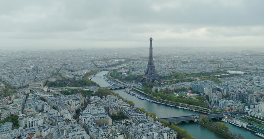 Beautiful view of famous Eiffel Tower in France with magical morning cloud and fog. Wide establishing aerial drone fly over seine river in paris city center, best travel destination landmark in Europe