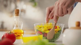 The parent, the young parent is deeply involved in the process tossing the salad on the kitchen table. In slow motion Expectant mother cooking green salad follows the modern principles morning salads - Powered by Shutterstock - Get 15% off with code: PIKWIZARD15