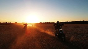 group of motorcyclists rides across the field, view of peoples, riding motorbike into sunset, driving across country road, free and happy, enjoy summertime, friends enjoy riding retro bikes