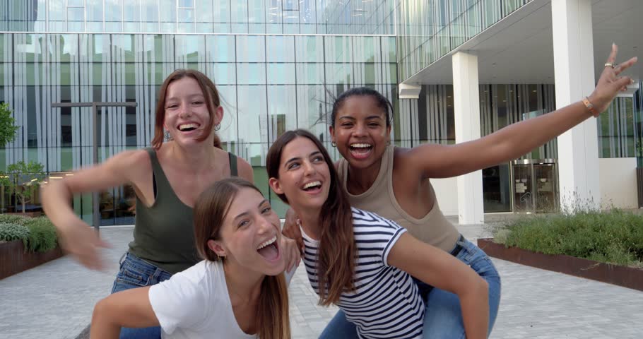 Group of girls friends teenager multiethnic students having fun in a university campus.
