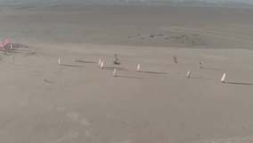 Land sailing on Hirel beach. France. A group of athletes on three-wheeled carts with sails conducts a lesson on the sandy shore. Drone video footage.