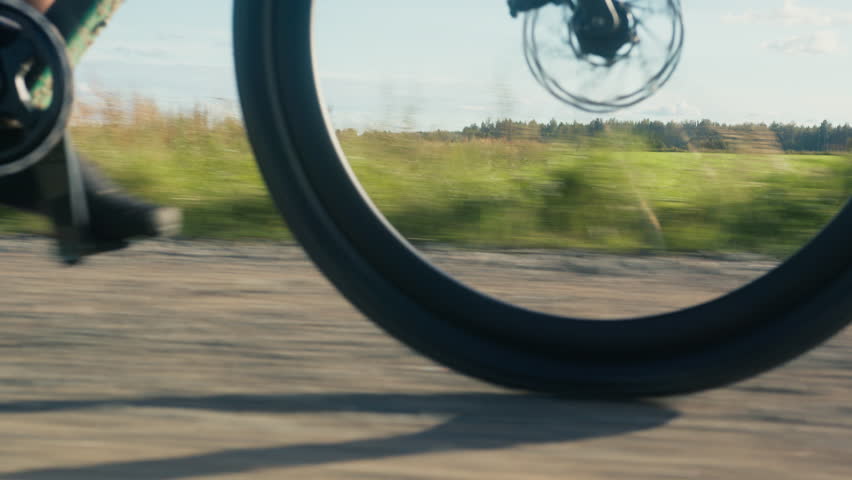 Gravel bike front wheel spinning from low angle. Driving through grain fields. Finnish countryside 4K