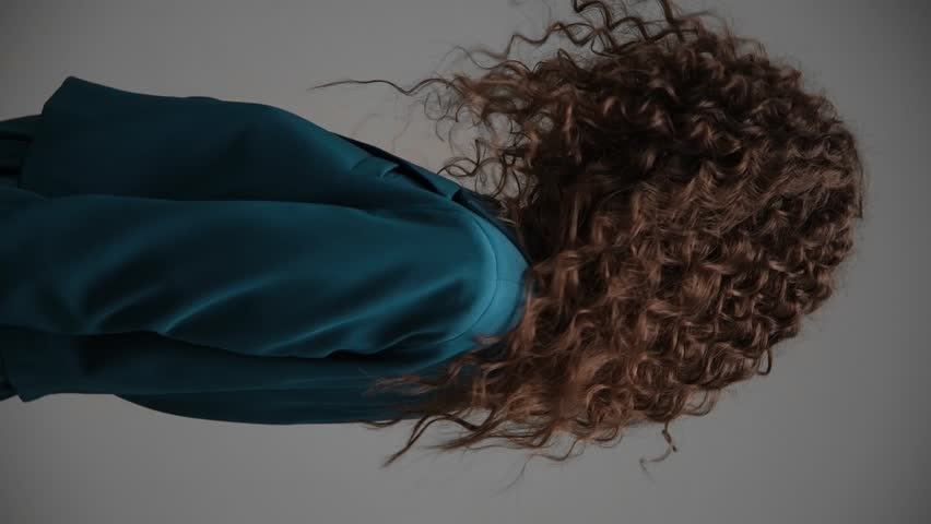 Beautiful brown-haired girl with a perfectly curly flying hair, classic make-up and a blue suit. Beauty face and hair. Royalty-Free Stock Footage #1107999767