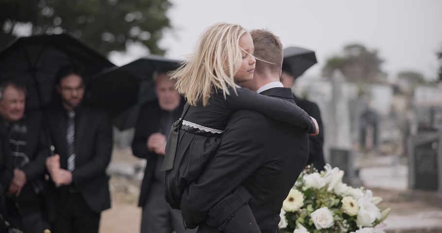 Sad, hug and a father and child at a grave for a funeral and mourning with a group of people. Holding, young and a dad with care and love for a girl kid at a cemetery burial and grieving together Royalty-Free Stock Footage #1108000049