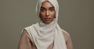 Fashion, face and a Muslim woman with a hijab on a studio background for classy and elegant style. Serious, beautiful and portrait of an Islamic model or girl with a headscarf isolated on a backdrop