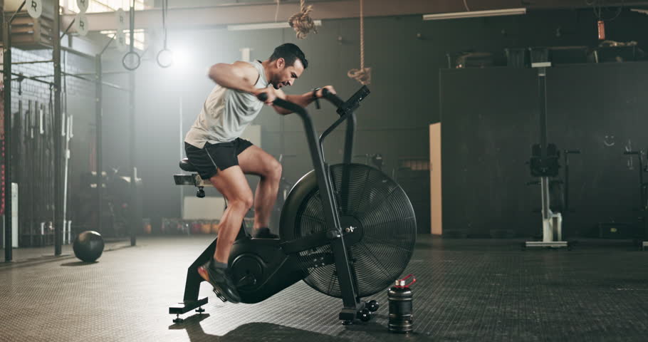Asian man, fitness and cycling at gym in cardio workout, exercise or intense training on machine. Active male person on bicycle equipment in sweat or running for muscle, endurance or stamina at club Royalty-Free Stock Footage #1108000181