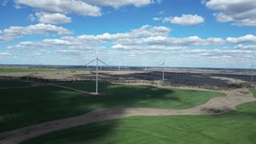 A newly constructed wind farm built on cattle grazing and cropping farmland producing green energy. Drone view