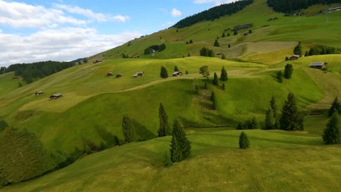 FPV drone flying above the cabins in Alpe di Siusi, Seiser Alm meadows at sunrise in the Dolomite mountains, Italian Alps. Video Stok